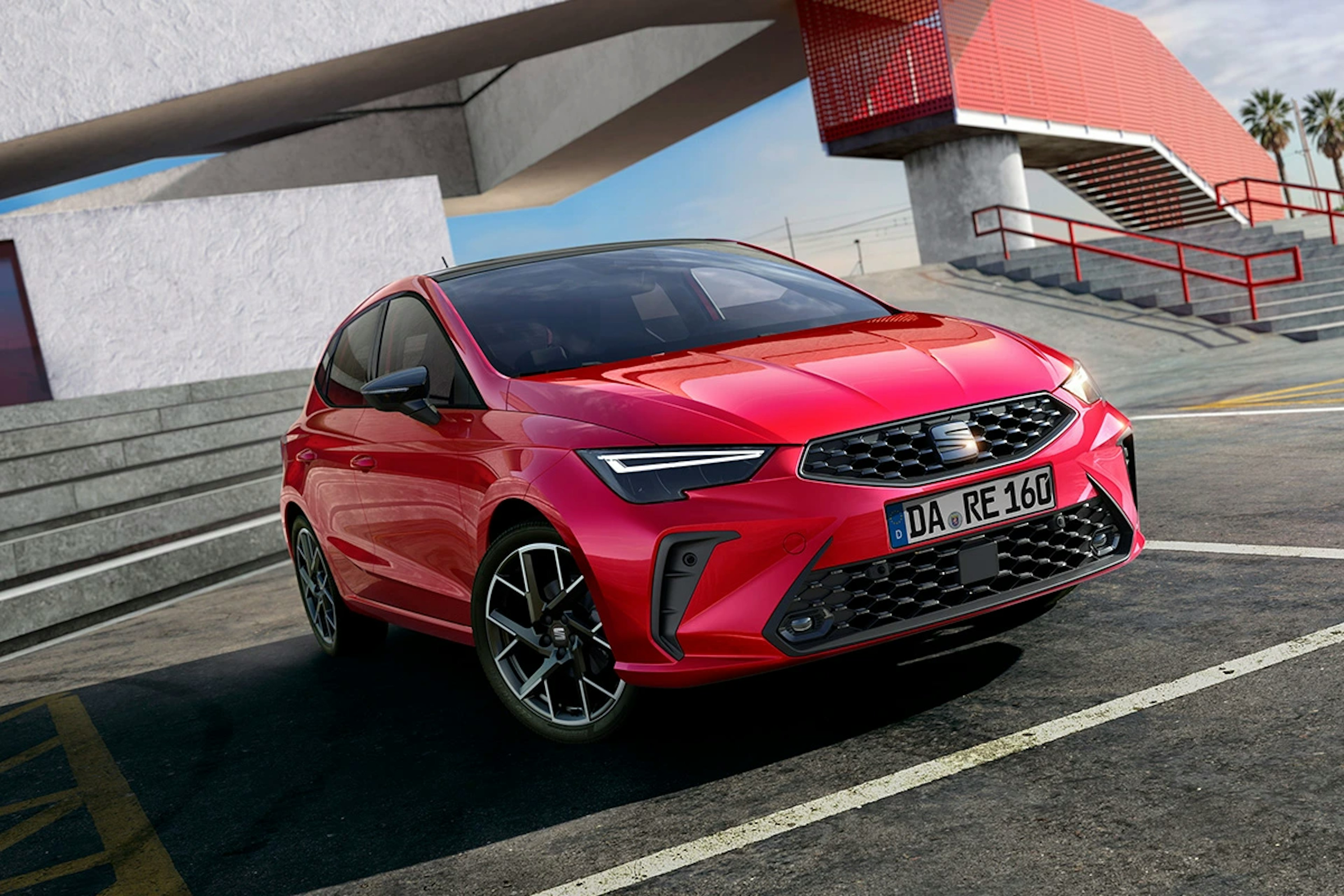 SEAT Ibiza in Rot vor moderner Architektur mit rotem Treppenelement
